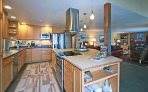 Enjoy cooking in the well-equipped kitchen with a microwave, refrigerator, and stove, and relax in the adjacent living area with a fireplace and comfortable seating.