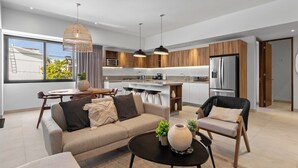 Ein modernes Wohnzimmer mit einer Couch, einem Couchtisch und einem Essbereich mit Stühlen.