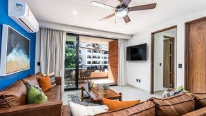 A modern living room with a brown leather sofa, a wooden coffee table, and a ceiling fan.