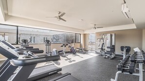 Un gimnasio moderno con cintas de correr, bicicletas estáticas y máquinas de pesas.