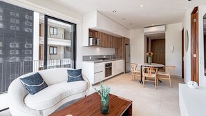Un apartamento moderno con sala de estar, kitchenette y comedor.