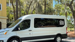 Una camioneta blanca estacionada en la calle, con un rótulo de administración de propiedades en la carrocería.