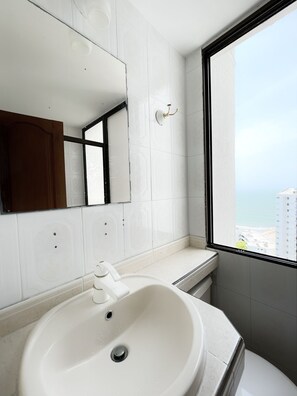 Sink, mirror, and geometric-patterned tiles adorn this bathroom.