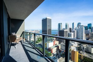 A balcony with a view of a city skyline, including a tall building with 'SKY' on it. - Apartment in New Luxury Condo Downtown (Miami)