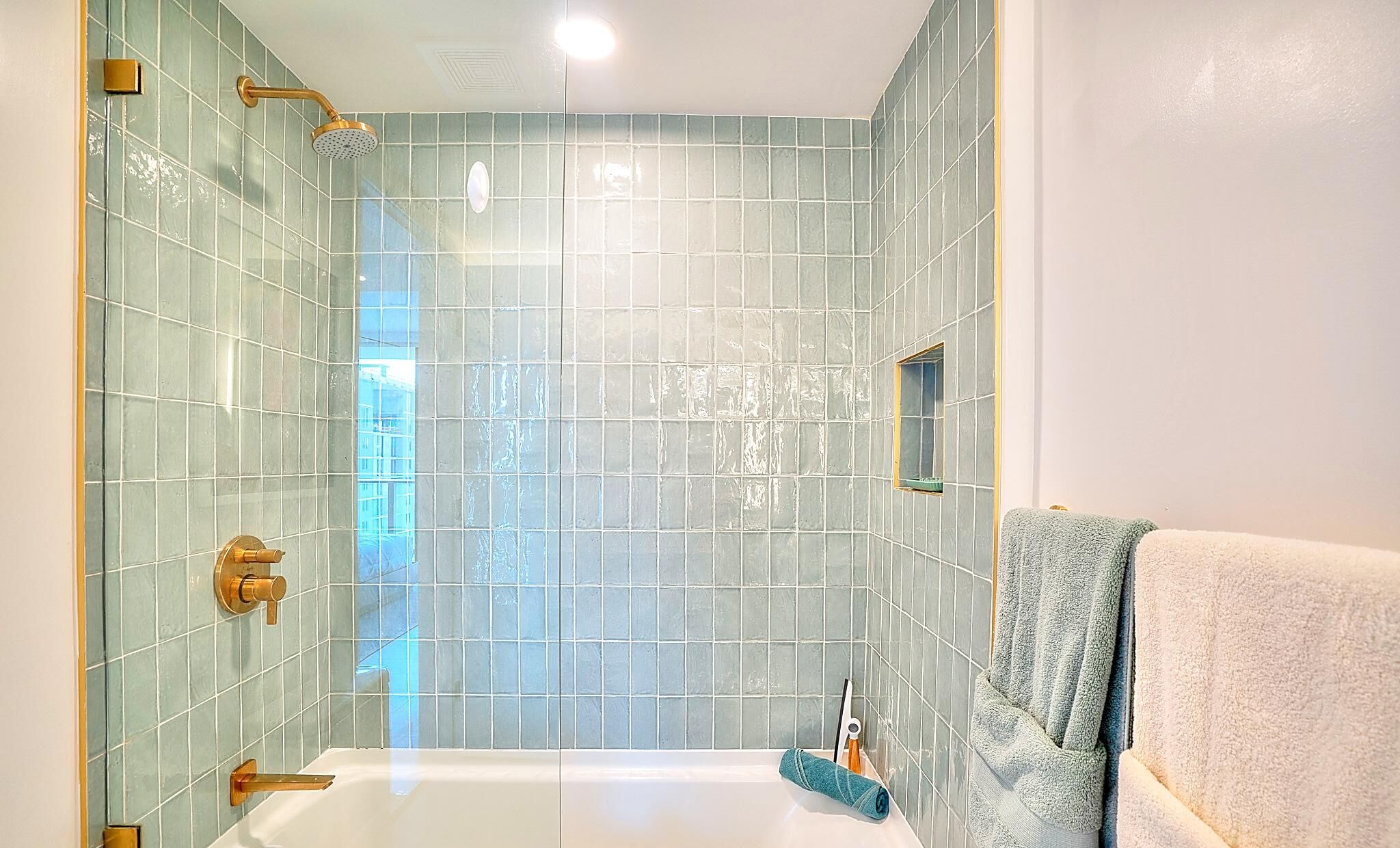A bathroom with a bathtub, a shower, and a towel rack.