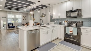 A modern kitchen with white cabinets, stainless steel appliances, and pendant lighting. - Ponte Vedra Beach Getaway w/ Patio! (Ponte Vedra Beach)