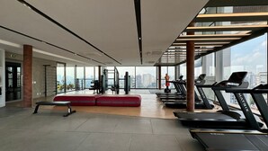 A modern gym with treadmills, benches, and exercise equipment, featuring large windows and a city view. - Vossa Bossa Moema (São Paulo)