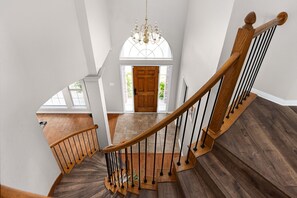 Eine hölzerne Wendeltreppe führt zu einer Tür mit Oberlicht.