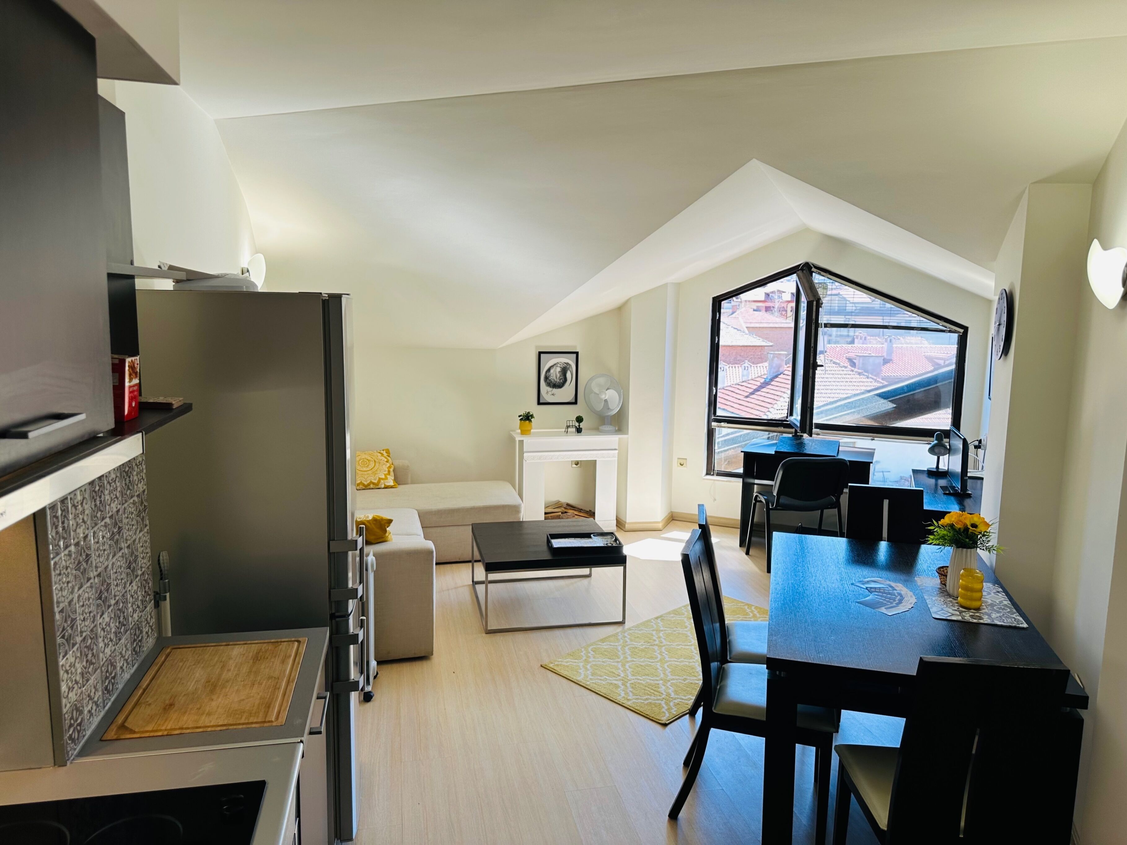 A modern apartment with a kitchen, dining area, and a cozy living space with a fireplace.