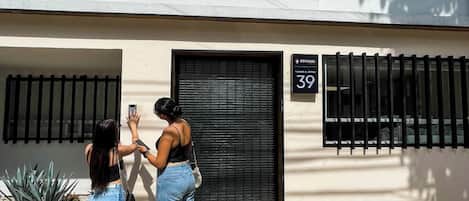 Un edificio con una reja negra, un cartel con el número 39 y una pequeña ventana sobre la reja.