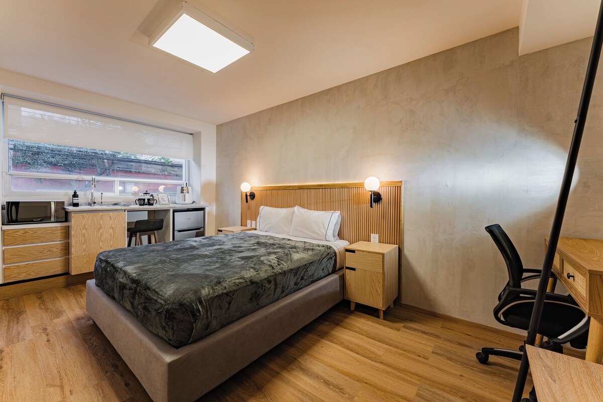Een moderne slaapkamer met een bed, nachtkastjes, een bureau en een stoel.