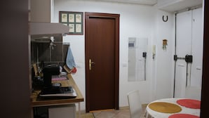A compact kitchen with a microwave, coffee maker, and a small dining area with a table and chairs. - Hazelrome apartment, cosy two bedroom apartment few steps from colosseum (Roma)