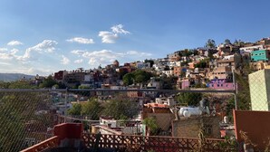 Un asentamiento en una ladera con construcciones de diversos colores y estilos arquitectónicos.