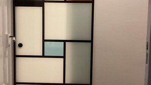 Eine Schiebetür mit einem Raster aus gefrosteten Glasfeldern in verschiedenen Farben.