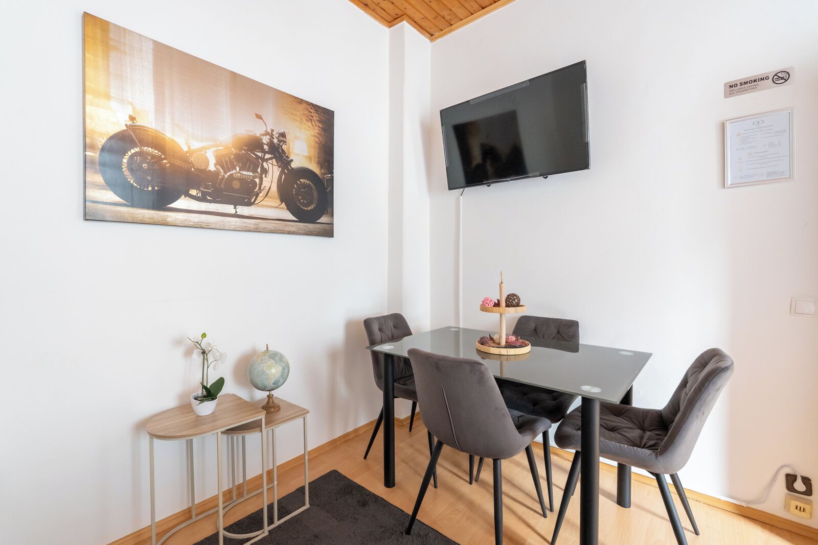 A dining area with a table, chairs, a globe, and a framed picture on the wall.