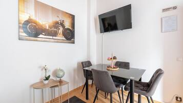 A dining area with a table, chairs, a globe, and a framed picture on the wall.