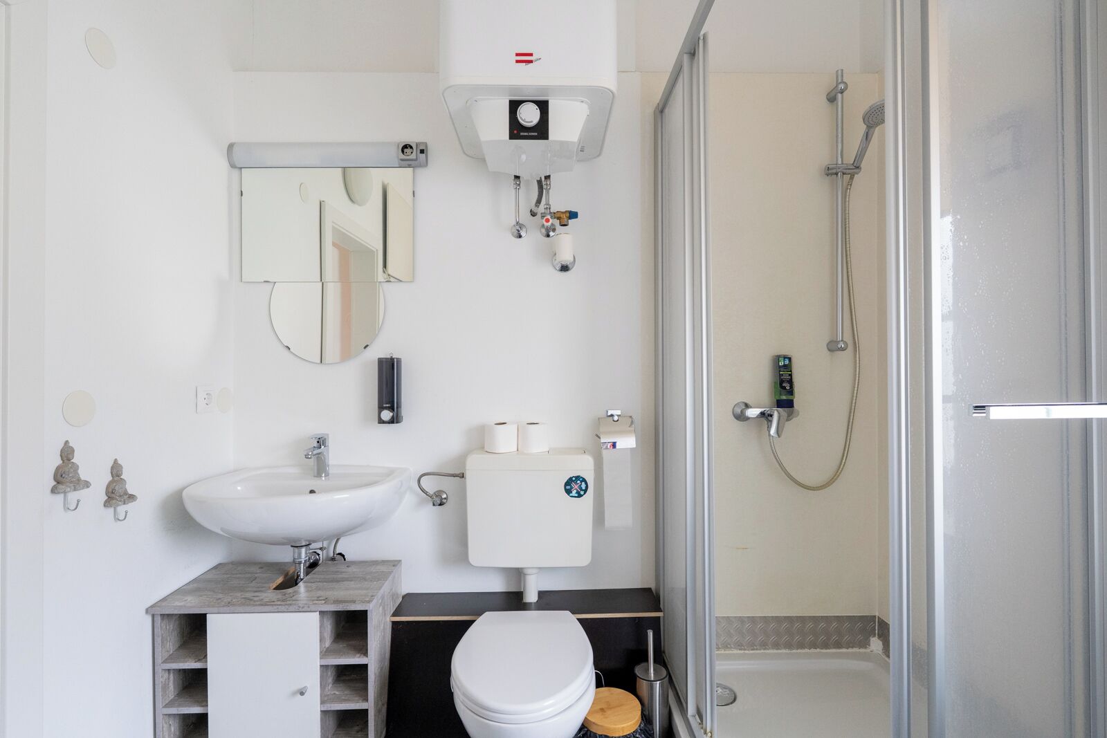 A modern bathroom with a sink, toilet, and shower.