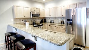 A kitchen with granite countertops, stainless steel appliances, and wooden cabinets. - Updated with a Modern Touch, Hot Tub, on the Eagle River (Avon)