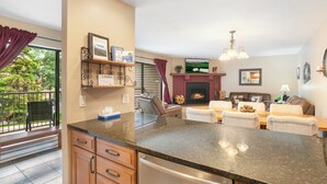 A modern kitchen with granite countertops, a built-in oven, and a dining area with a fireplace.
