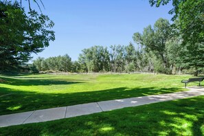 A park with a grassy area, a paved walkway, and a bench. - Beautiful Mountain Condo 10 Minutes from Beaver Creek, BBQ (Edwards)