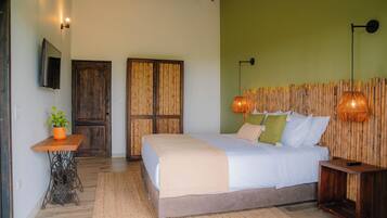 A bedroom with a bed, bedside table, and a wall-mounted TV.
