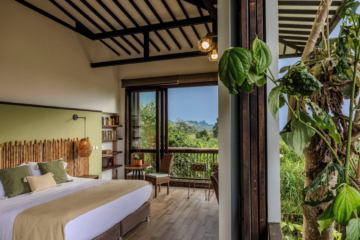 A bedroom with a bed, a chair, a table, and a bookshelf.