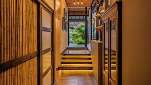 Un pasillo estrecho con escaleras de madera que conducen a un jardín.