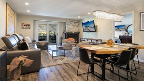 A modern living room with a fireplace, a dining area, and a large window. - A gem in the heart of Avon. Walk to the Lifts! (Avon)
