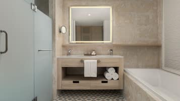 A modern bathroom with a large mirror, two sinks, a bathtub, and a patterned floor.