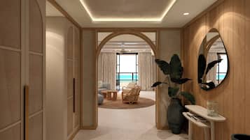 Una habitación de hotel moderna con un amplio arco que da a un balcón con vistas al mar. Cuenta con una zona de estar con sofá y sillones, y una mesita con un jarrón de flores.