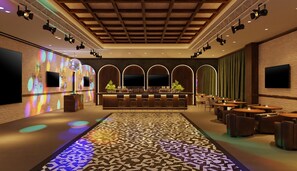A bar area with a patterned floor, seating, and a bar counter.