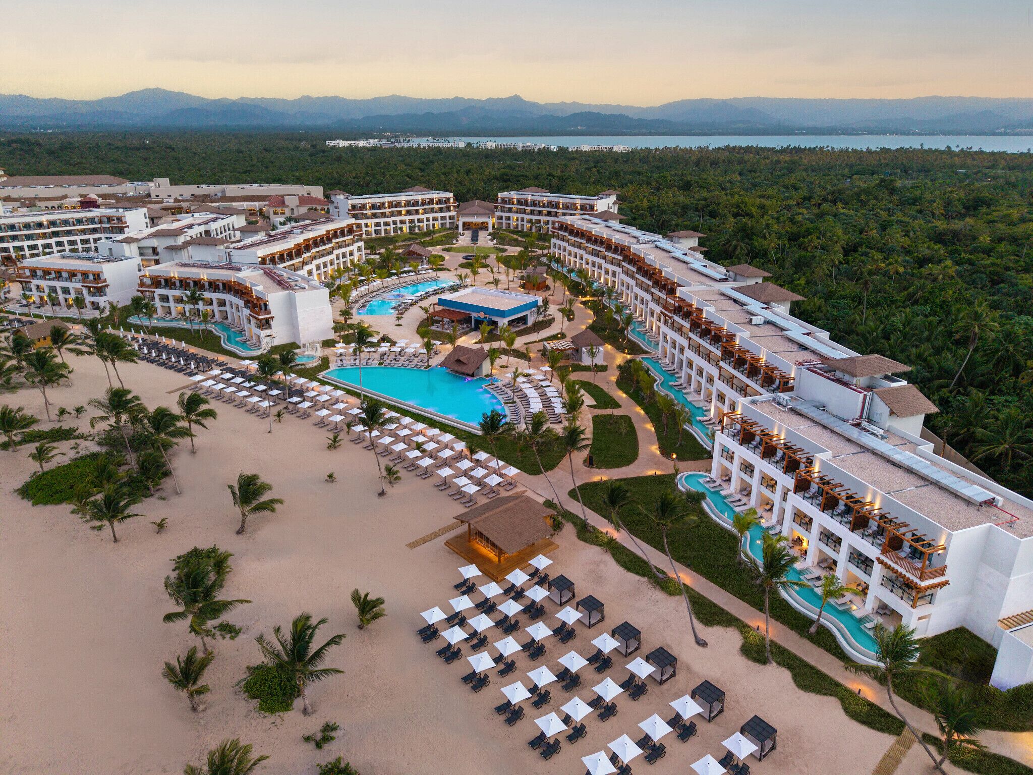 Un complexe hôtelier doté de plusieurs piscines, d’une plage et offrant une vue sur les montagnes.