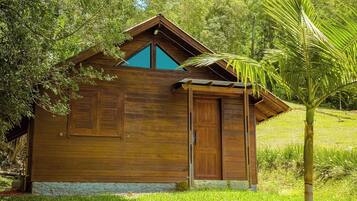 A wooden cabin with a sloped roof, a door, and a window.