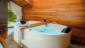 Une salle de bain moderne avec une grande baignoire, des murs en bois et un puits de lumière.