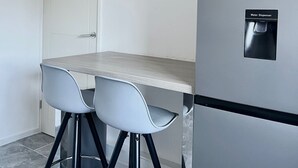 Μια κουζίνα με ψυγείο, ρολόι και διανομέα νερού.