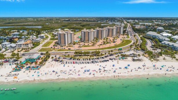Une station balnéaire dotée de villas en bord de mer, d’une plage de sable et d’un port de plaisance.