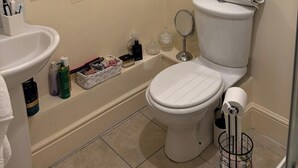 Un baño con inodoro, lavamanos y cabina de ducha de vidrio.