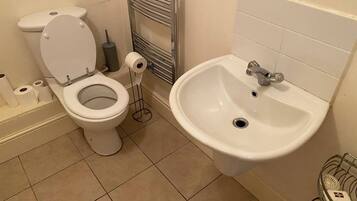 Un baño con inodoro, bidé y lavamanos.
