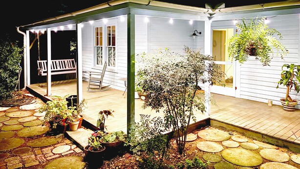 A covered porch with a swing, potted plants, and a wooden deck. - Charming Home 2 miles to UGA (Athens)