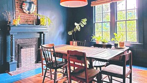 A dining area with a brick wall, a fireplace, and a large window with multiple panes. - Charming Home 2 miles to UGA (Athens)