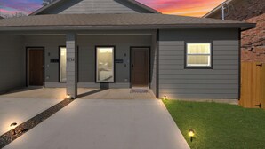 Ein zweistöckiges Haus mit Veranda, Garage und gepflegtem Rasen.