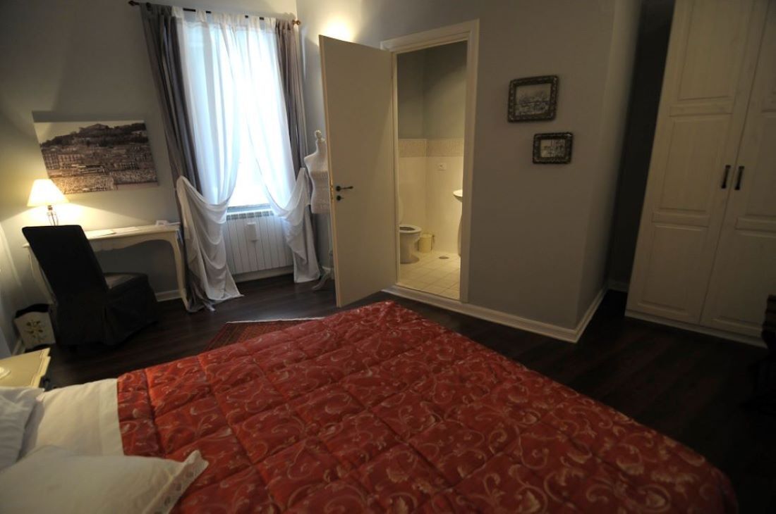 Un dormitorio con cama, escritorio, silla, zona de ducha y armario.