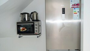 A compact kitchen with a stainless steel refrigerator, a built-in oven, and a microwave. - Furnished MinVilla (duplex)  (Ouad-Eddahab Dakhla)