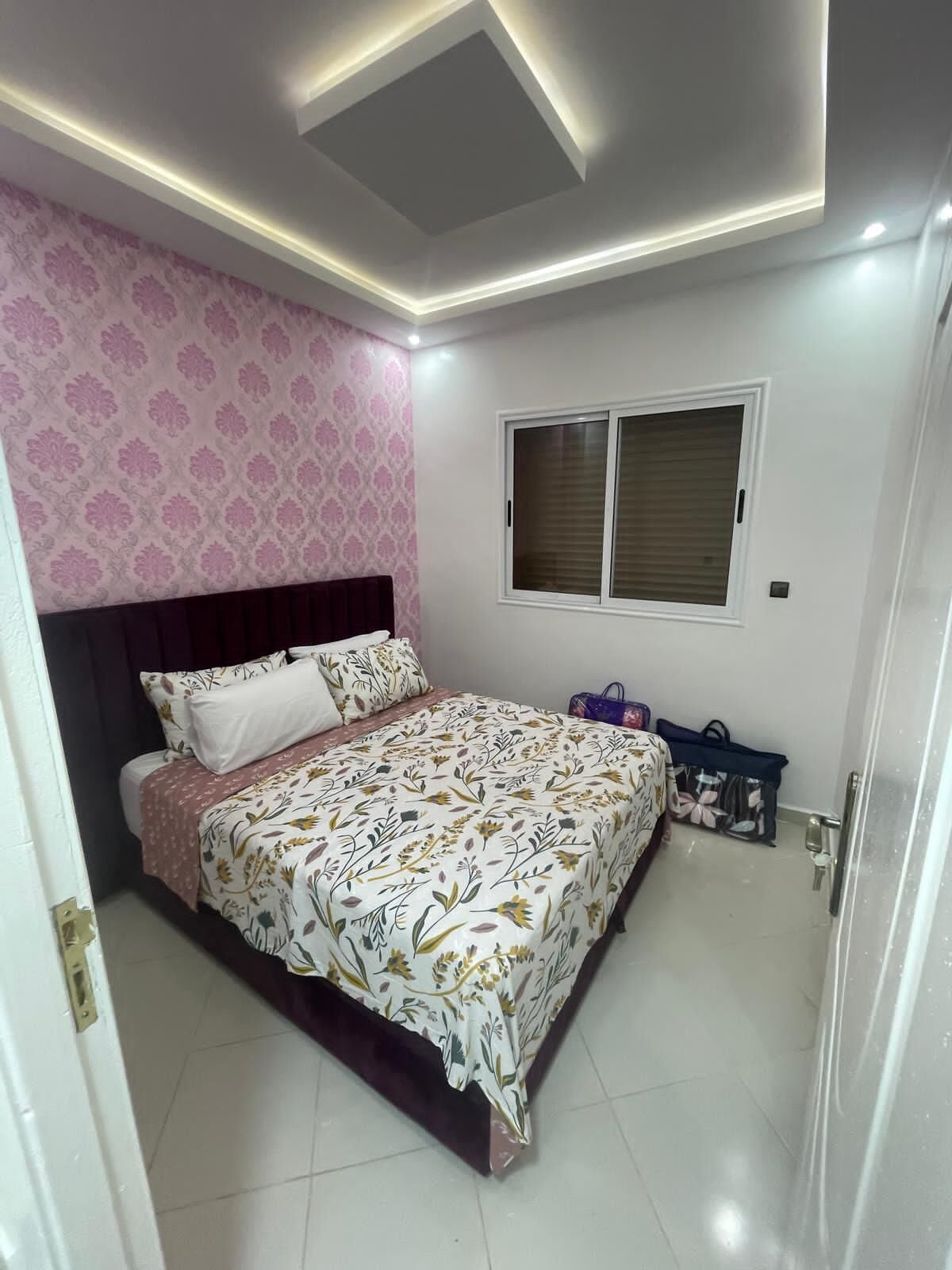 Une chambre à coucher avec un lit, une fenêtre et une porte.