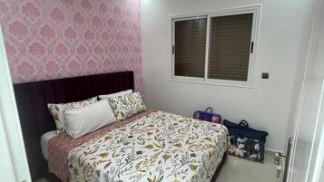 Une chambre à coucher avec un lit, une fenêtre et une porte.