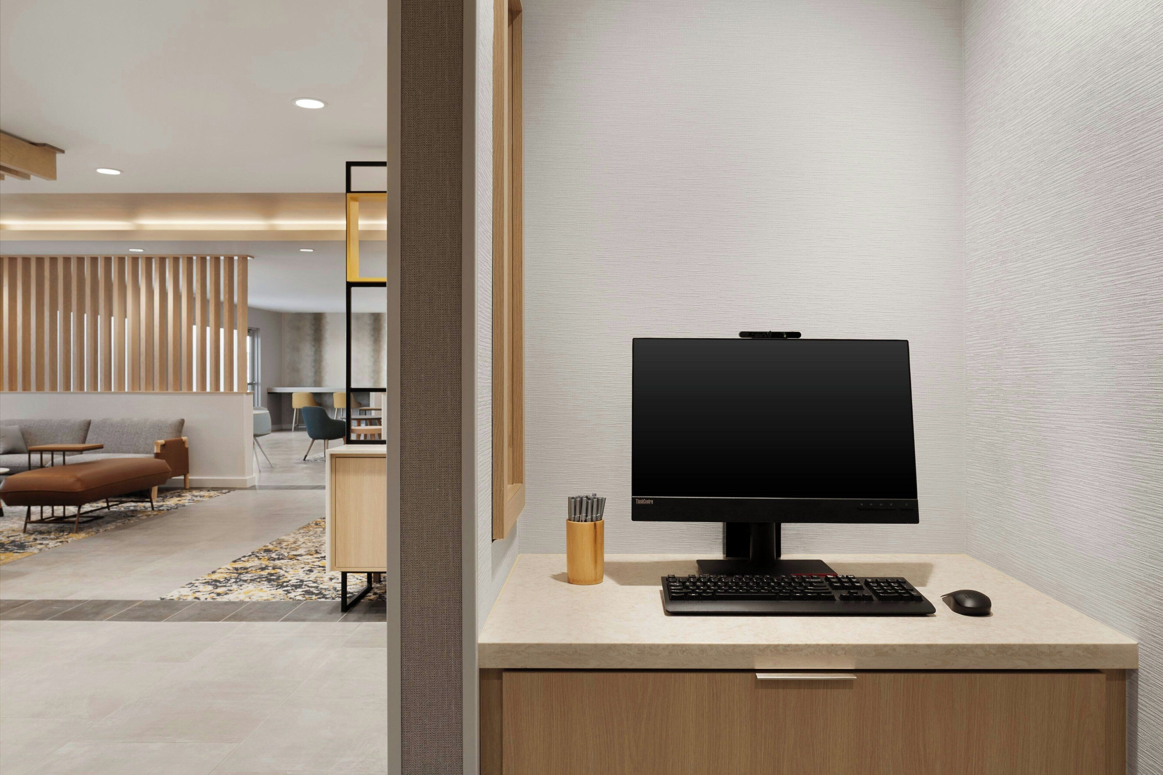 A modern office desk with a computer monitor, keyboard, and mouse.