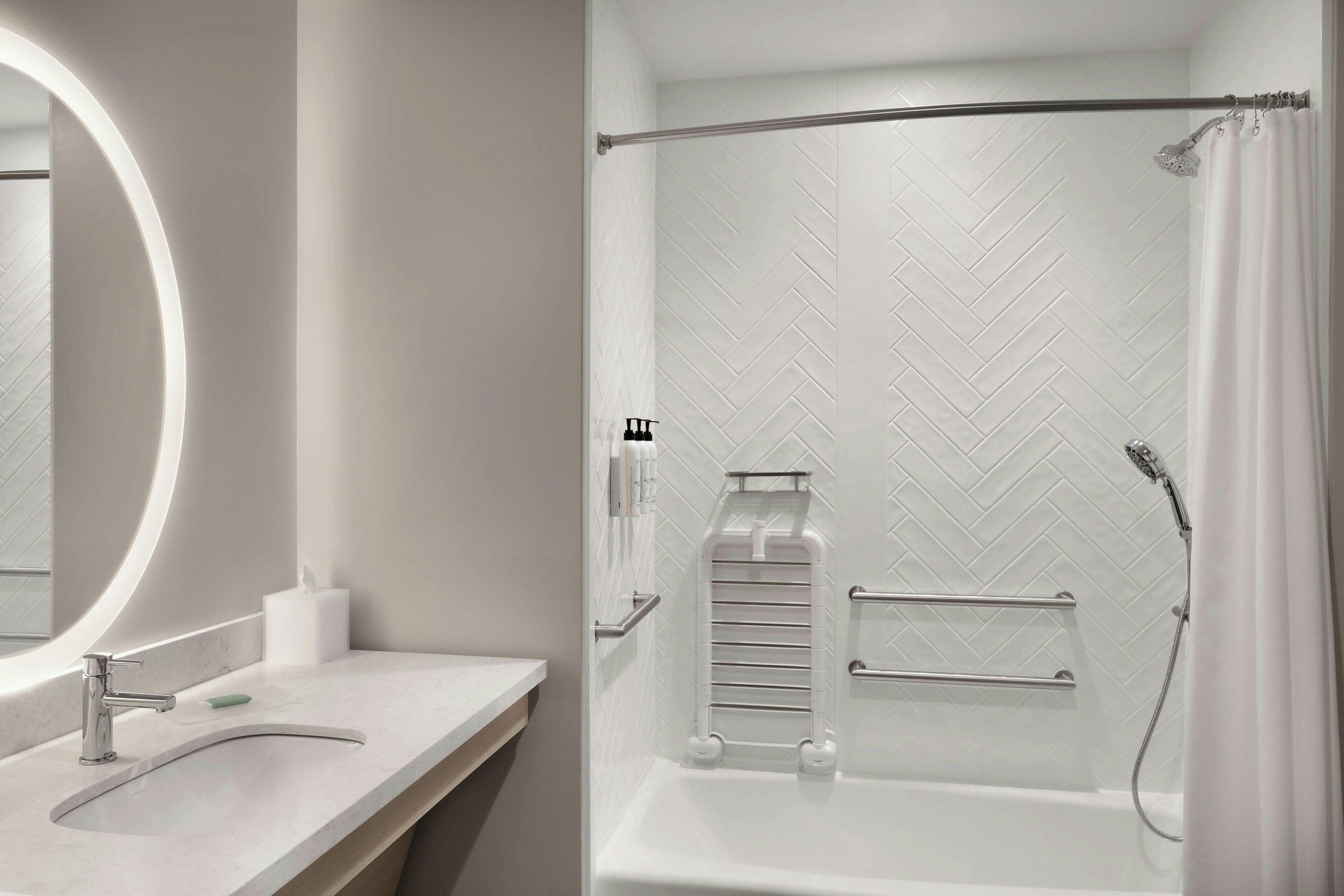 A modern bathroom with a white sink, mirror, and shower.