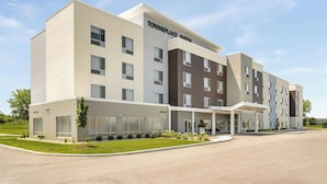 A modern hotel with a flat roof, a covered entrance, and a sign reading "Towneplace Suites". - Towneplace Suites By Marriott Crown Point (Crown Point)