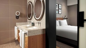 Une salle de bain moderne avec deux lavabos, un miroir et des toilettes.