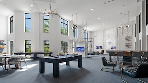 Un espace intérieur vaste et lumineux, doté d’une table de billard, de sièges confortables et de grandes fenêtres laissant entrer la lumière naturelle.